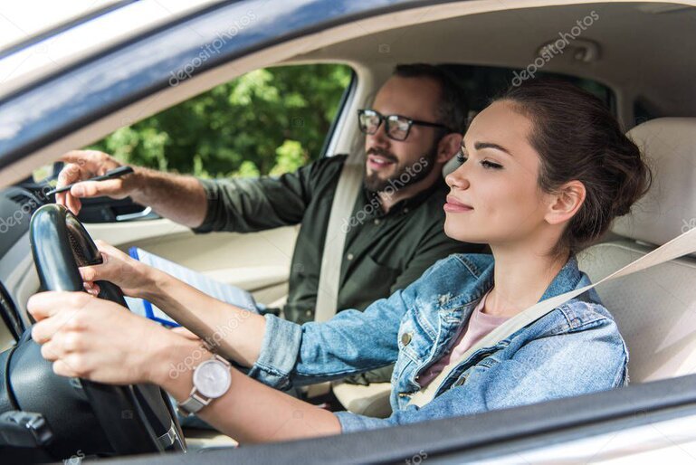 Driving instructor coaching a learner in a dual-control car